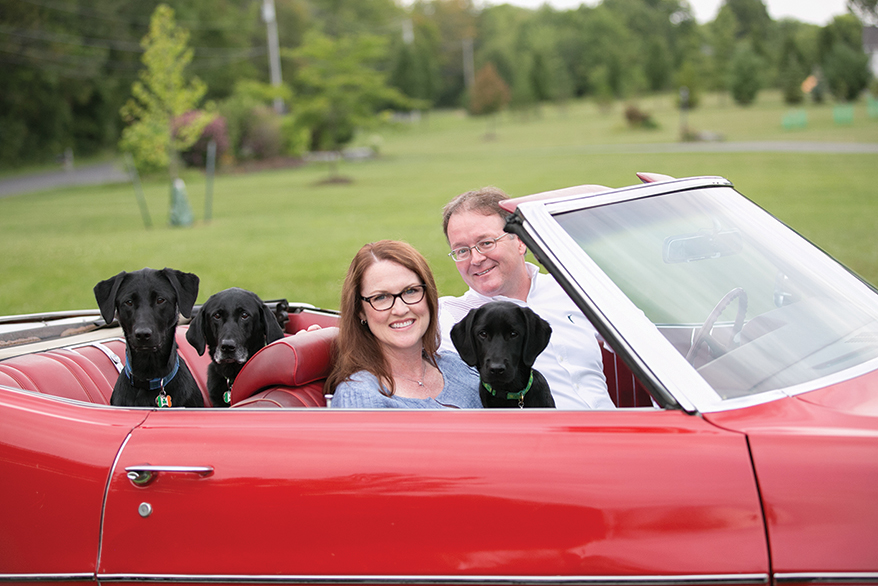 Amy and Pat take a ride with three of their beloved Labradors.: from left, Saoirse, the late Kennedy and puppy Caoimhe.